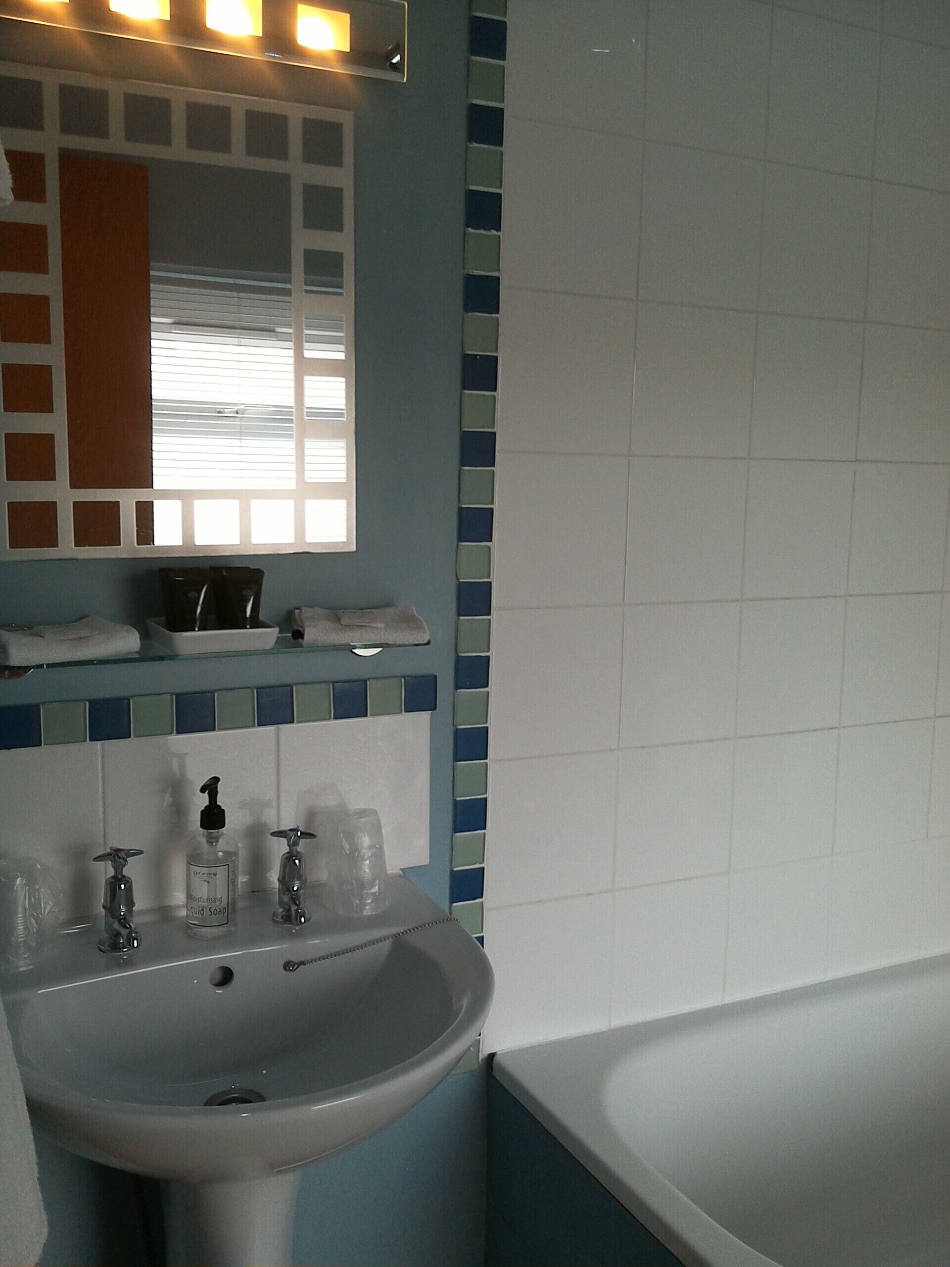 Ein Badezimmer mit Waschbecken, Spiegel und Badewanne.