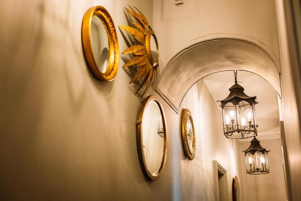 A hallway with multiple mirrors and a decorative ceiling light fixture.