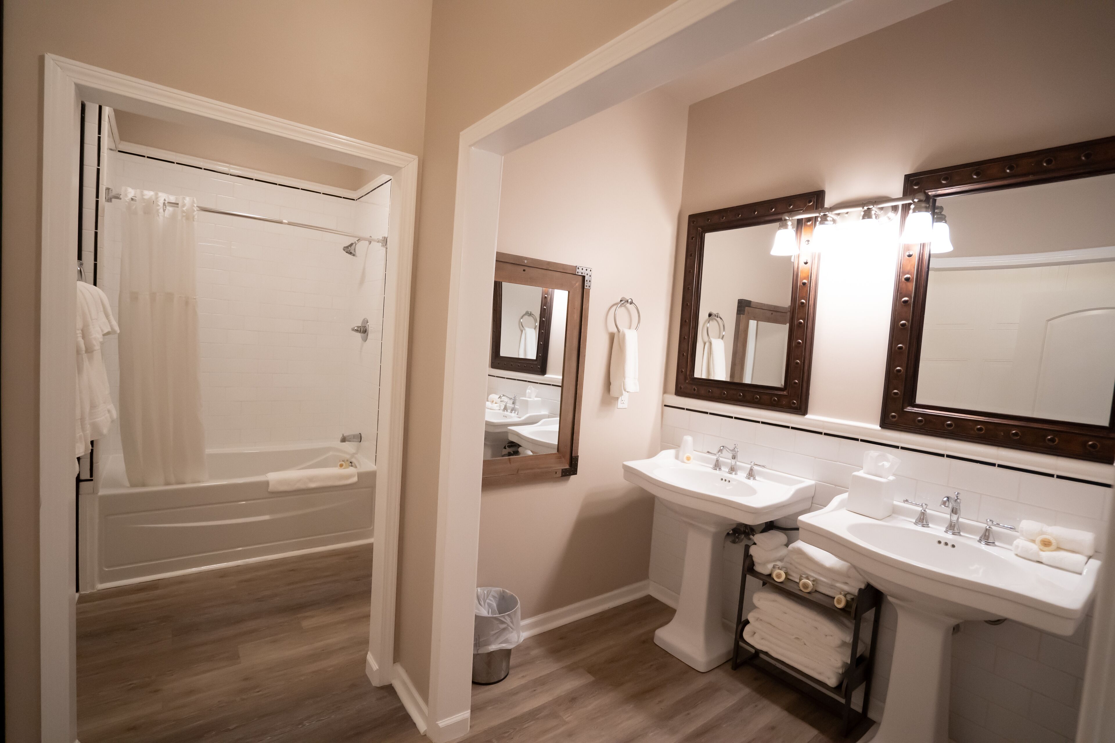 A bathroom with a bathtub, two sinks, and three mirrors.
