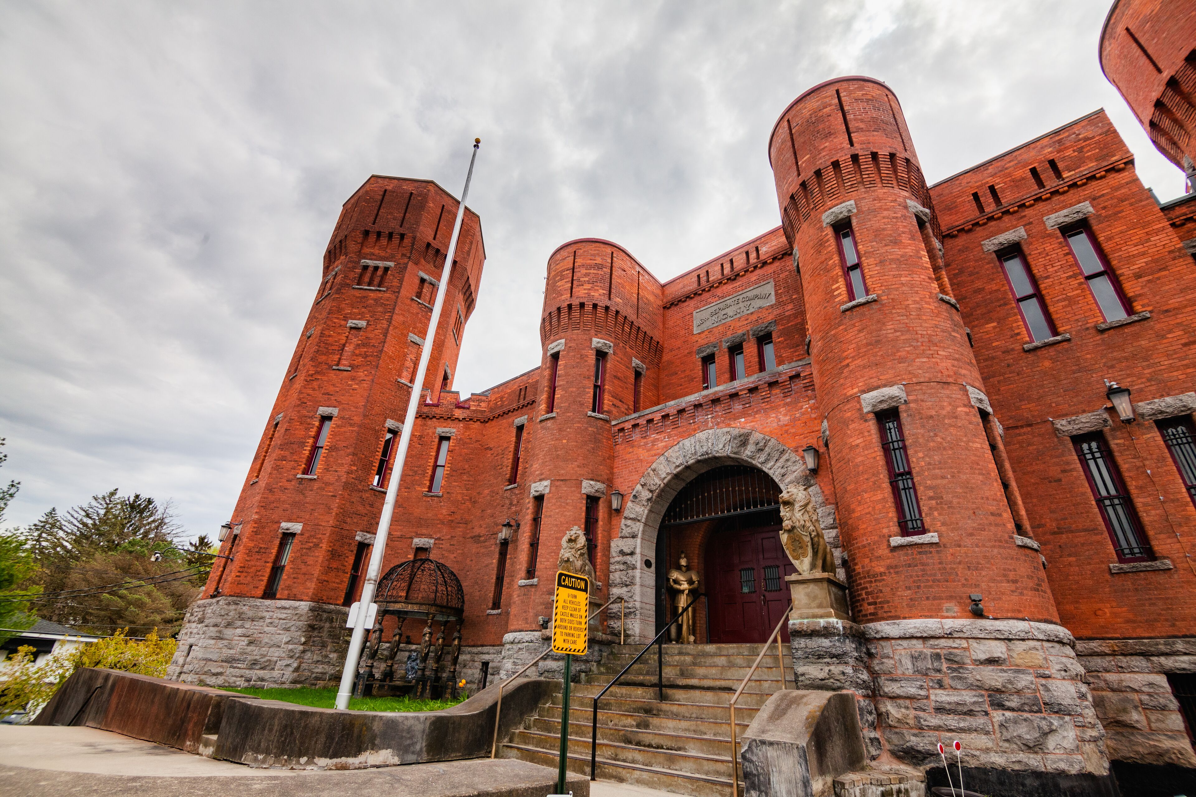 A large brick building with multiple towers and arched windows.