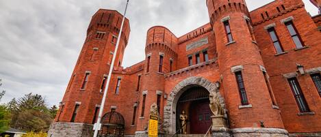 A large brick building with multiple towers and arched windows.