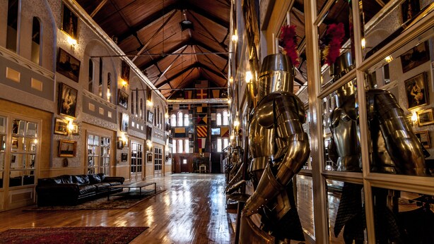 A spacious interior with high ceilings, wooden floors, and a central seating area with a red rug. - Amsterdam Castle (Amsterdam)