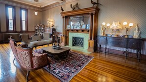 A spacious living room with a fireplace, wooden floors, and classic furniture. - Amsterdam Castle (Amsterdam)