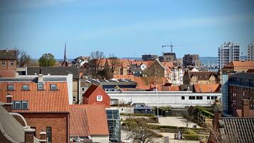 A cityscape with a mix of traditional and modern architecture, including a prominent building with a red roof and a bank sign.