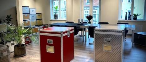 Ein geräumiges Büro mit großen Fenstern, Holzböden und zwei rollbaren Stauraumeinheiten.