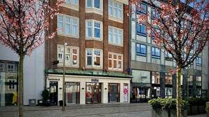 A hotel with a traditional facade, multiple windows, and a ground-level entrance with a sign. - Teaterhotellet (Horsens)