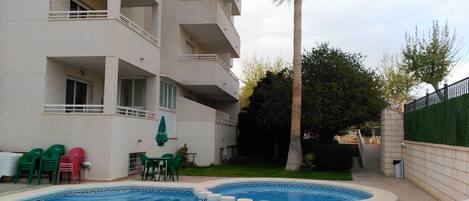 Alberca al aire libre, sombrillas en la alberca y camastros