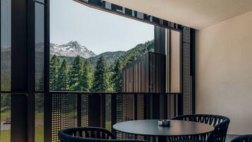 Una habitación moderna con un ventanal grande con vistas a un paisaje montañoso.