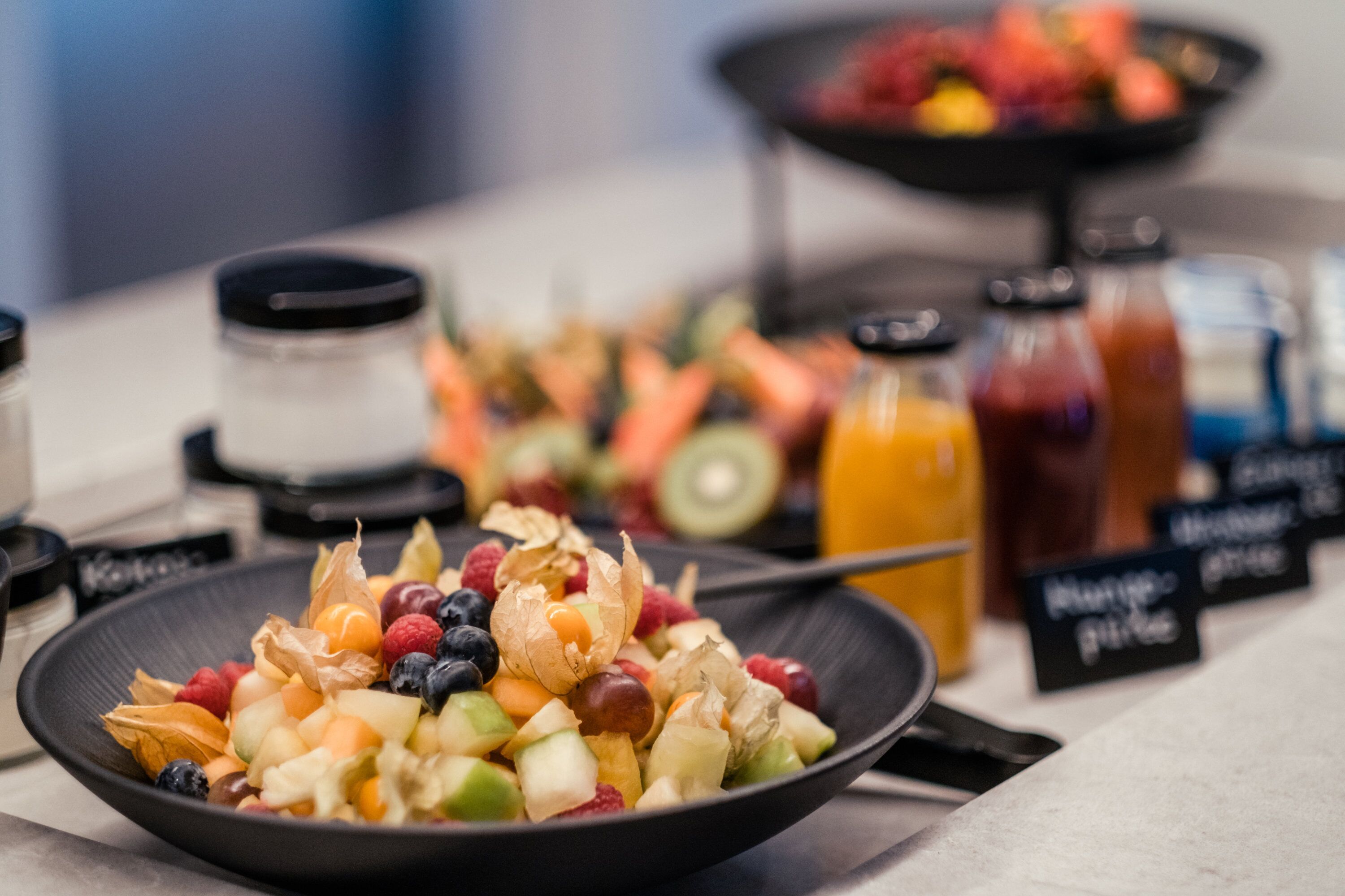 Un bufé de desayuno con diversas frutas y bebidas.