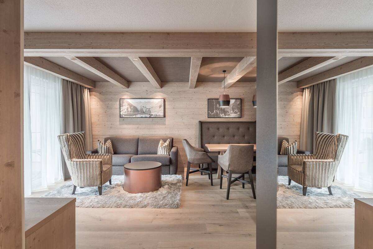 A modern living room with a sofa, chairs, a coffee table, and artwork on the walls.