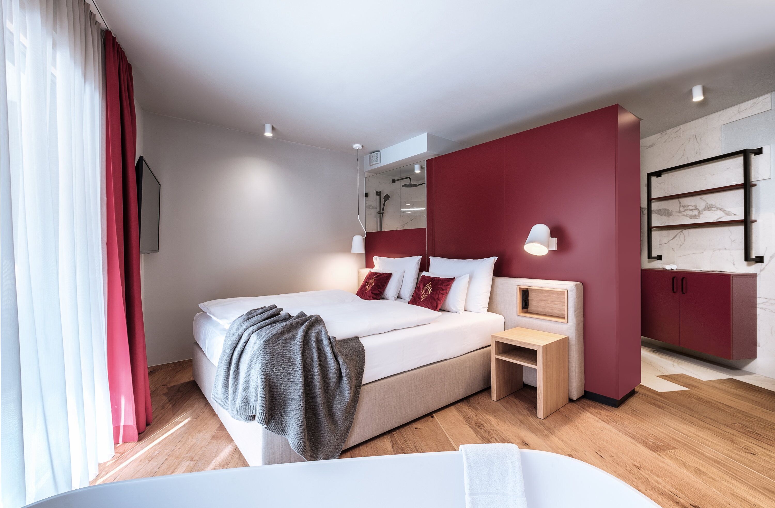 A modern bedroom with a bed, bedside table, and built-in wardrobe.