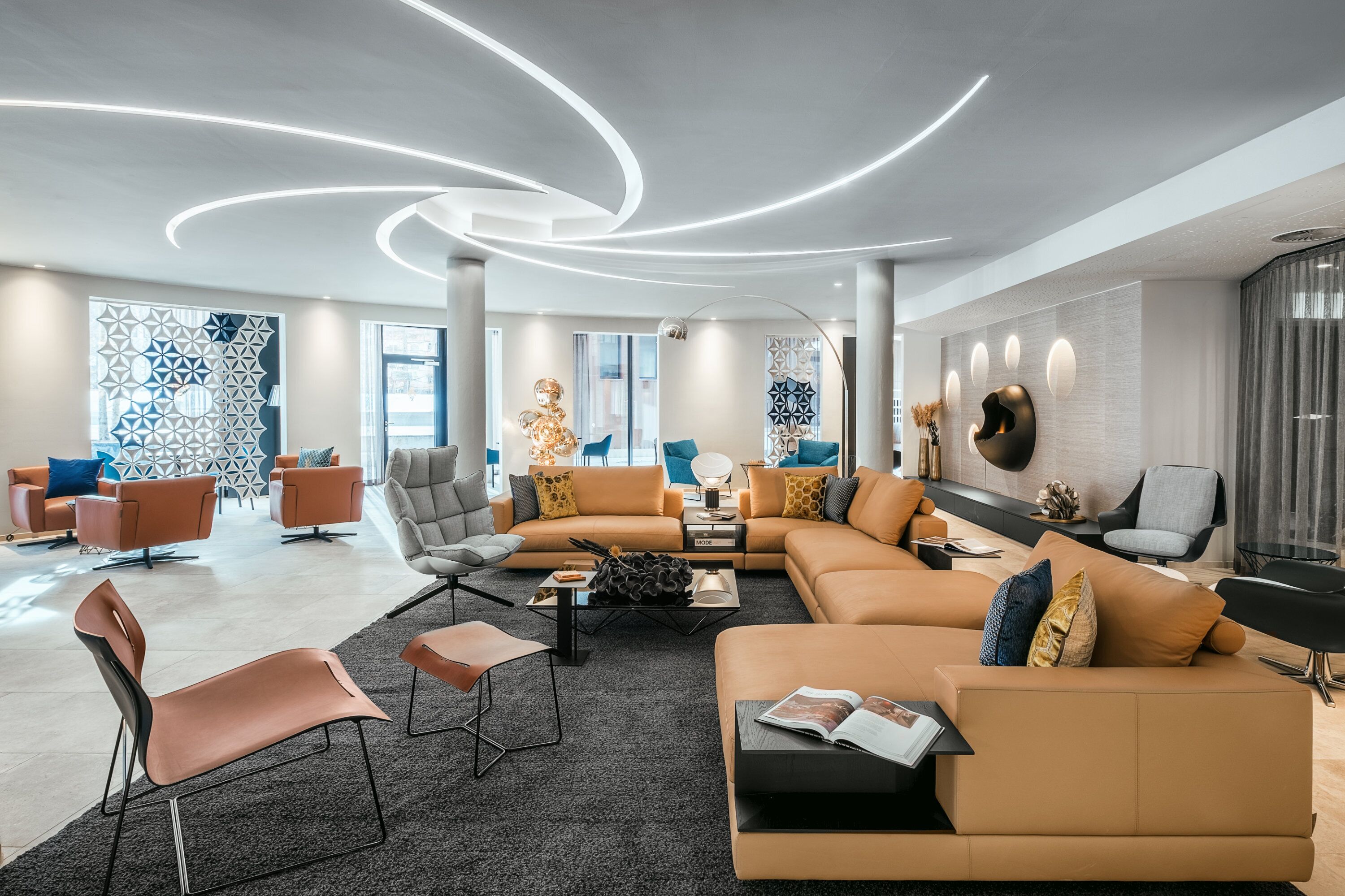 Una sala de estar moderna con un sofá modular, sillones y una mesa de centro.