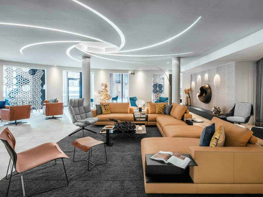 Una sala de estar moderna con un sofá modular, sillones y una mesa de centro.