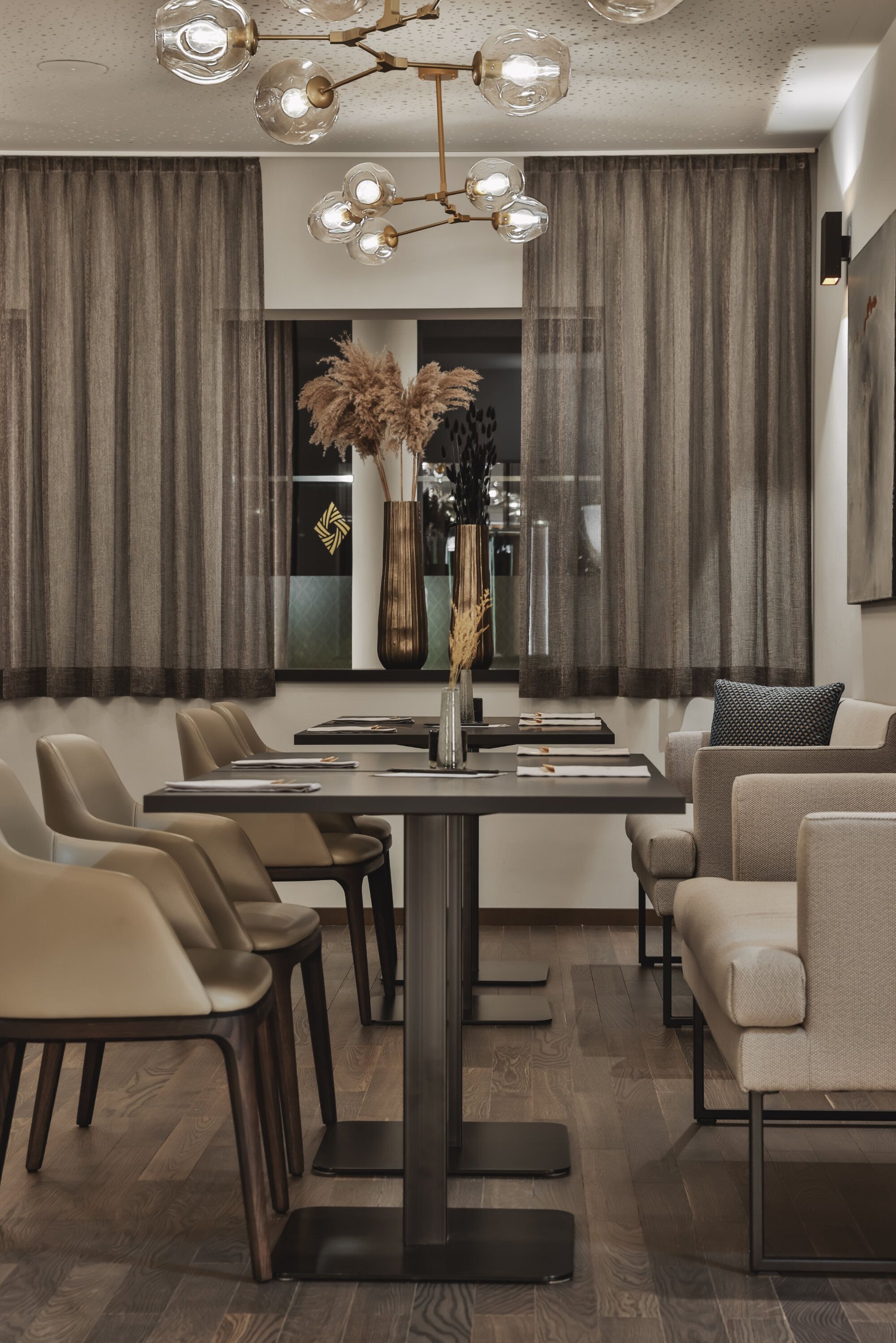 Un espace repas moderne avec une table centrale, plusieurs chaises et un vase décoratif.