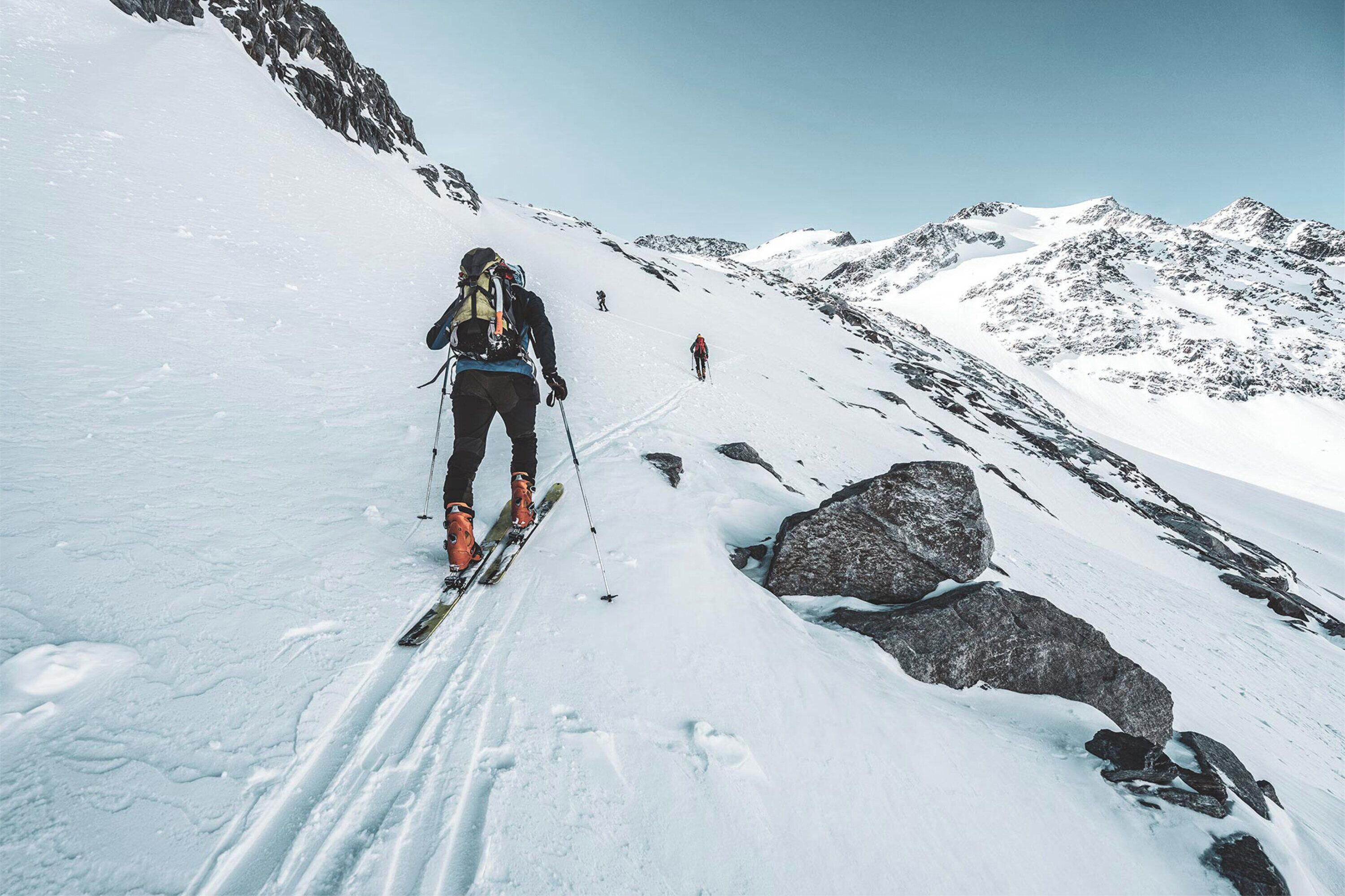 A snowy mountain path with skiers.