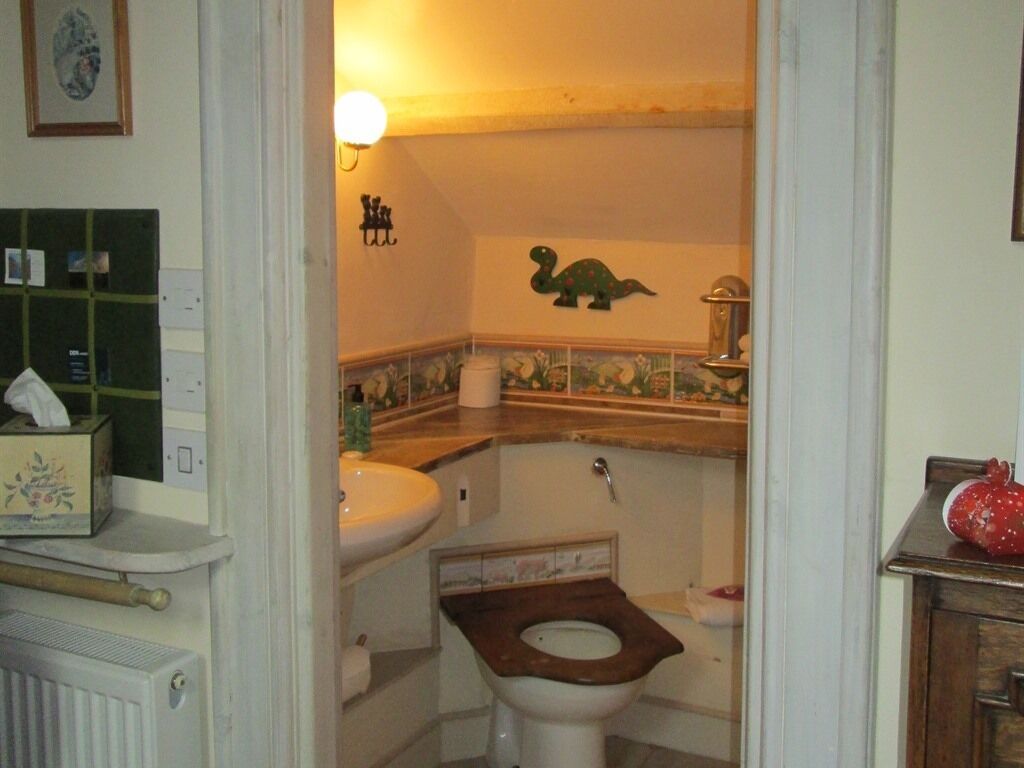 A bathroom with a toilet, sink, and decorative wall.