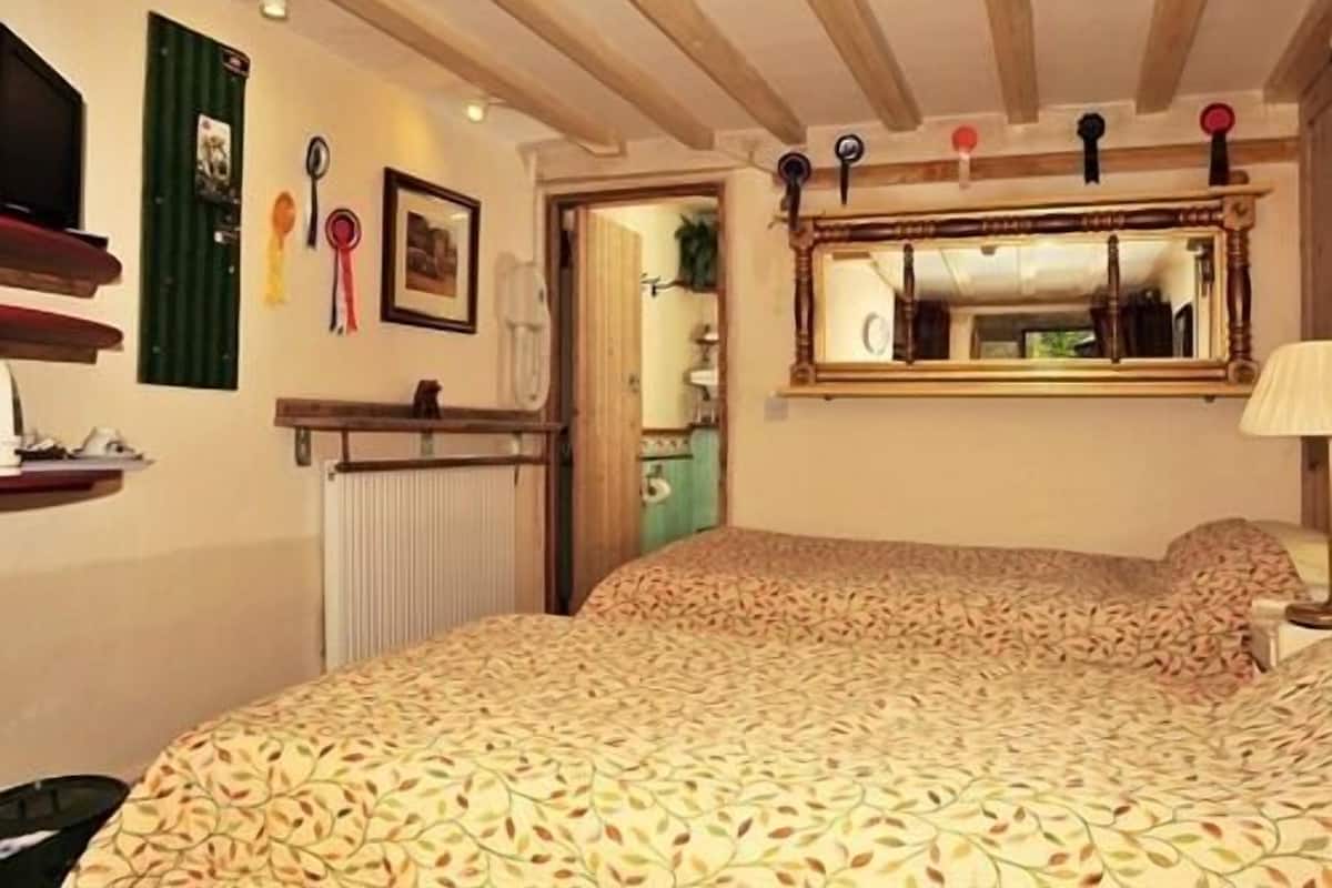 Quarto com uma cama, um espelho e um radiador.
