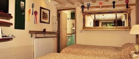 A bedroom with a bed, a mirror, and a radiator.