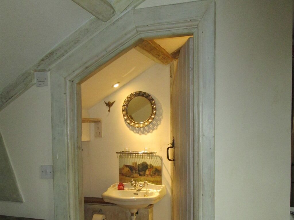 A bathroom with a sink, mirror, and a small bird figurine on the wall.