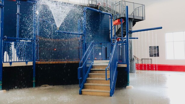 A water slide with blue railings and stairs leading up to it. - Holiday Inn Omaha Downtown - Waterpark by IHG (Omaha)