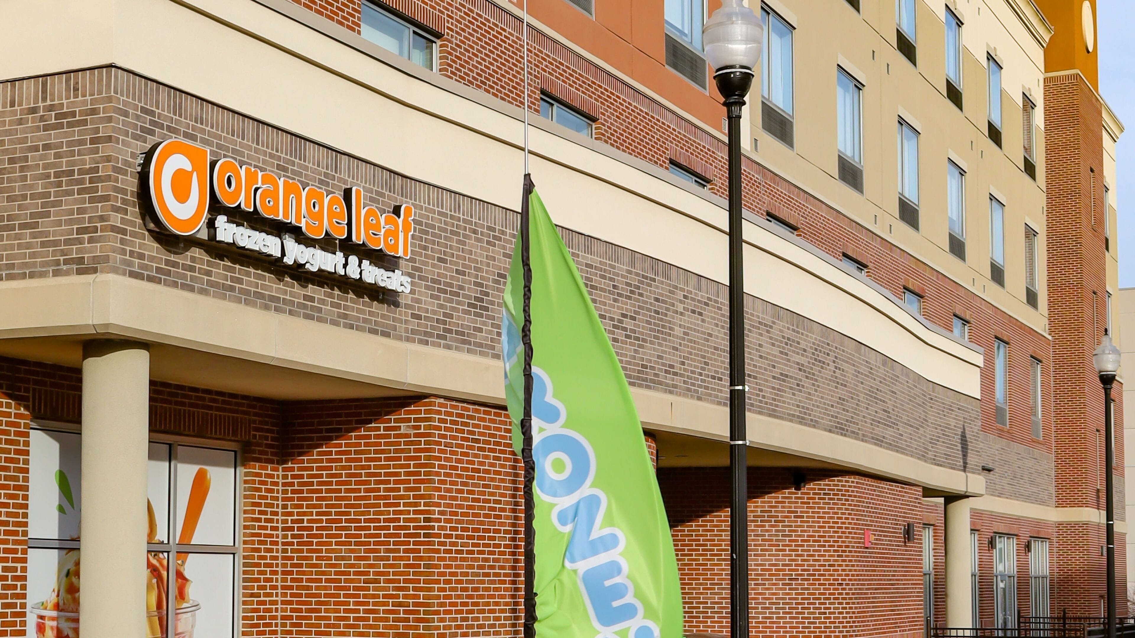 Un edificio con un letrero que indica 'Orange Leaf Frozen Yogurt & Treats'.