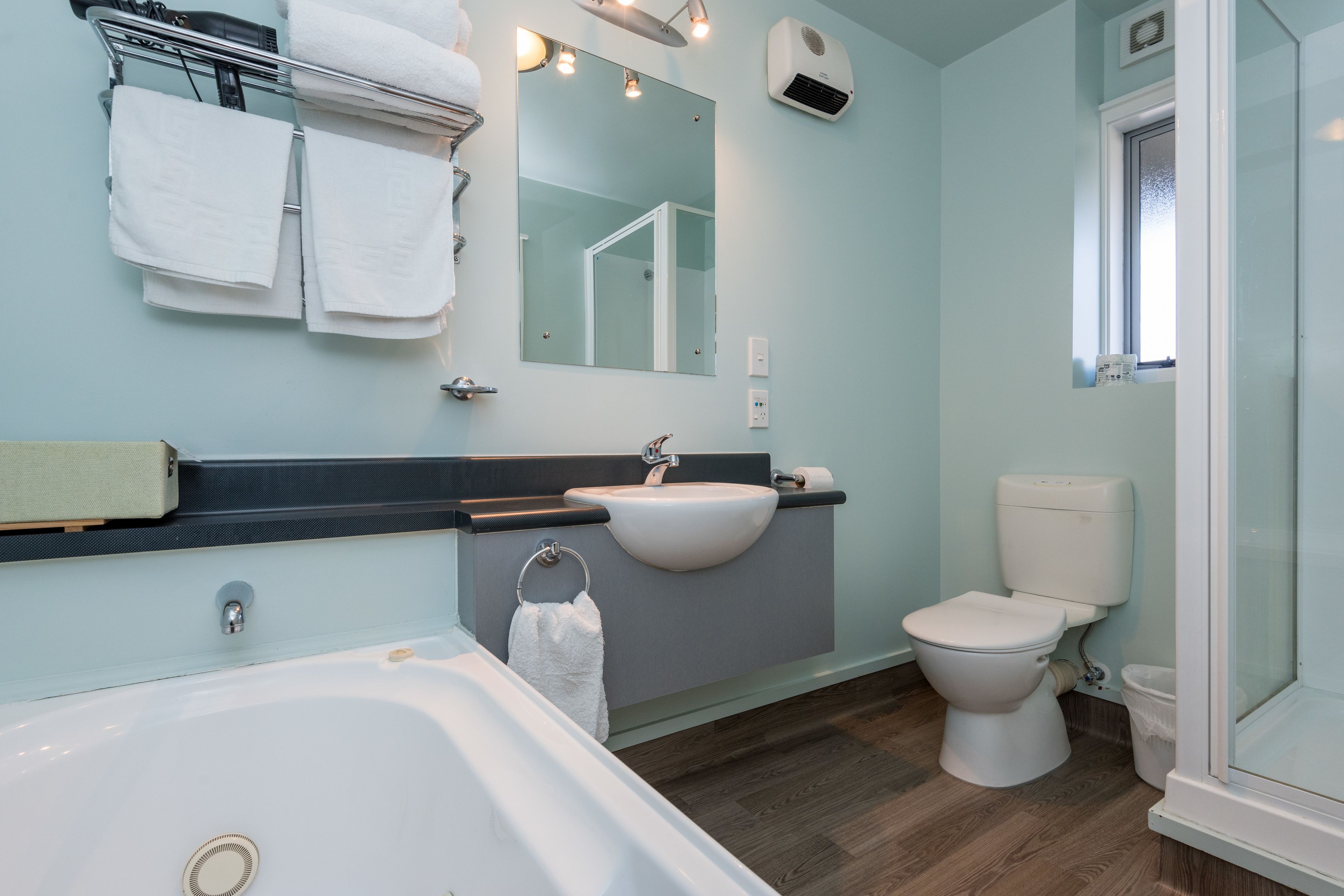 Een moderne badkamer met een bad, wastafel en toilet.
