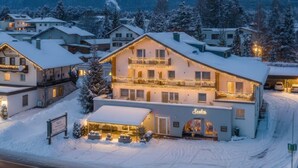 Un hôtel dont l’extérieur est recouvert de neige et sur lequel on peut lire l’inscription « Seelos ».