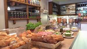 Un buffet de petit-déjeuner proposant un assortiment de pains, de viennoiseries et diverses boissons.