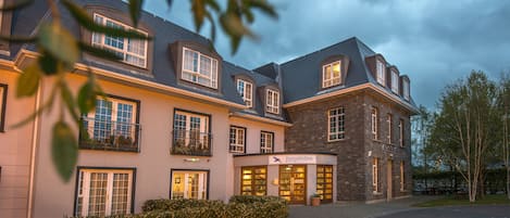 Vista frontal de la propiedad por la tarde o noche