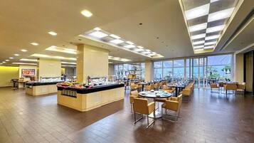 Un amplio comedor con un mostrador para buffet, varias mesas y sillas.
