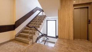 Un interior moderno con una escalera, una pared de madera y una puerta.