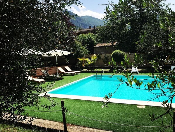 Una piscina al aire libre de temporada, sombrillas