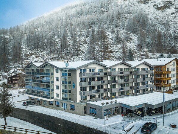 Un hotel de varios pisos con diseño moderno, que cuenta con balcones y ventanas amplias.