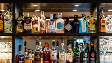 Um bar com diversas garrafas de bebidas e copos.