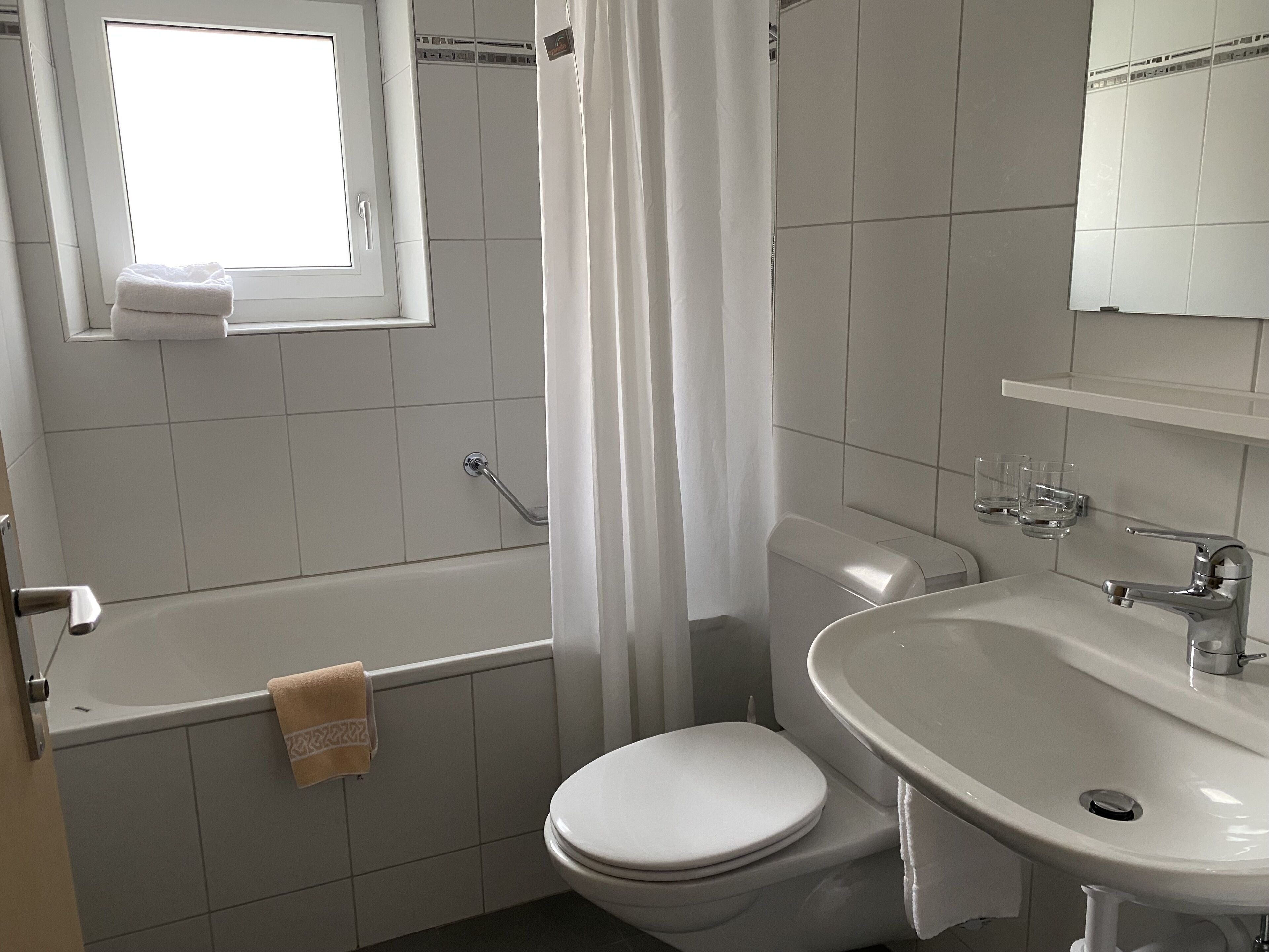 A bathroom with a bathtub, toilet, and sink.