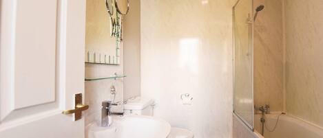 A bathroom with a toilet, sink, and shower.