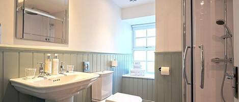 A bathroom with a sink, toilet, and shower.