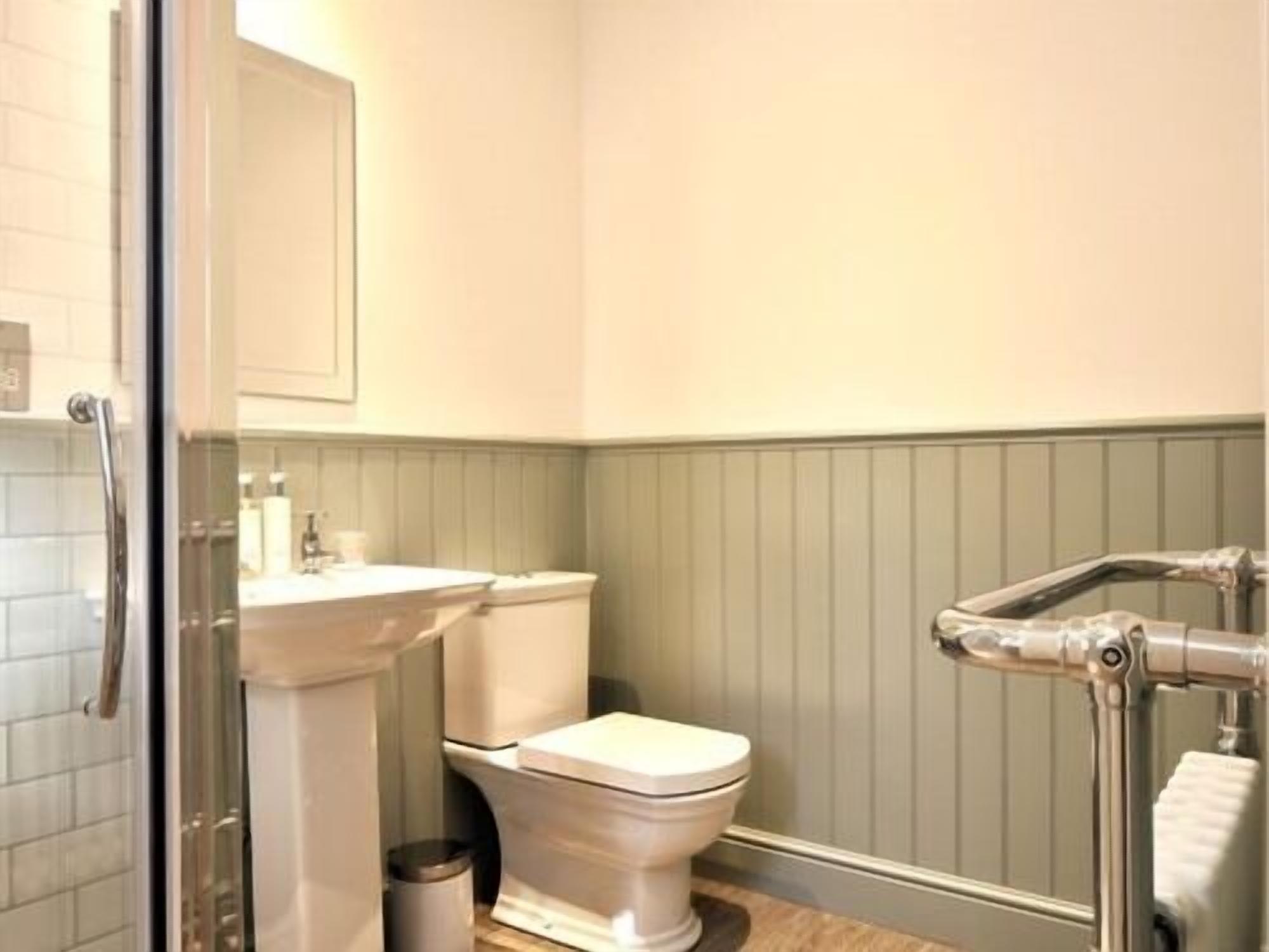 Une salle de bain équipée de toilettes, d’un lavabo et d’une douche à parois en verre.