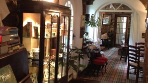 A cozy interior with a piano, books, and a dining area with red chairs and a table. - The Black Swan (Kirkby Stephen)