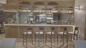Una zona de bar con mostrador y cuatro taburetes.