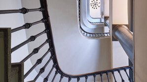 En spiraltrappa med ett metallräcke och utsikt över våningen ovanför.