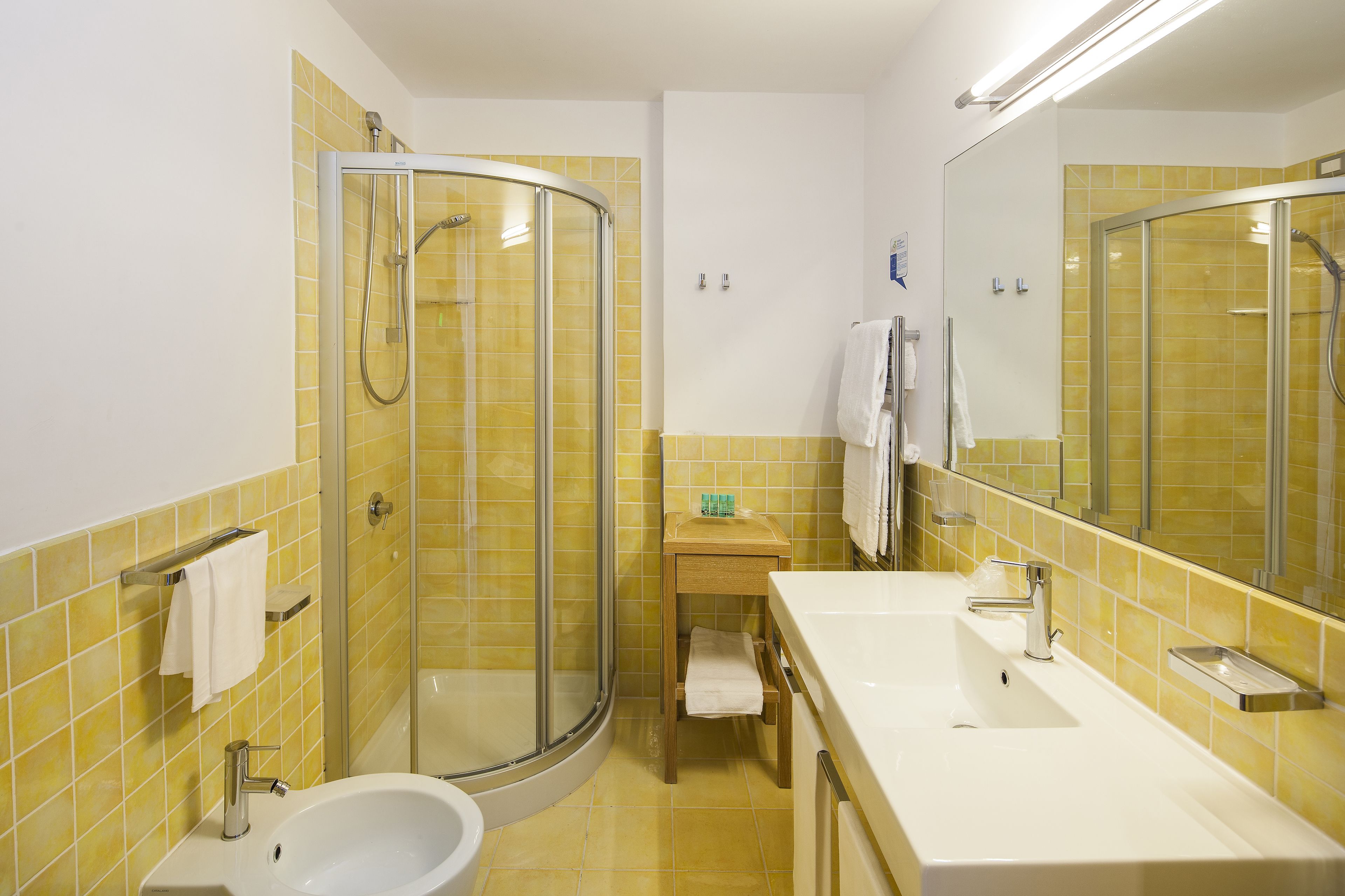 A bathroom with a shower, sink, and toilet.