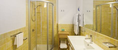 A bathroom with a shower, sink, and toilet.