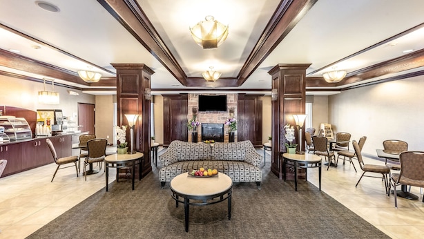 A spacious lobby with a central seating area, a fireplace, and a coffee station. - Red Lion Inn & Suites Mineral Wells (Mineral Wells)