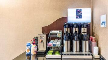 A coffee station with a DUNKIN' HOT water dispenser, coffee makers, and a variety of coffee pods.