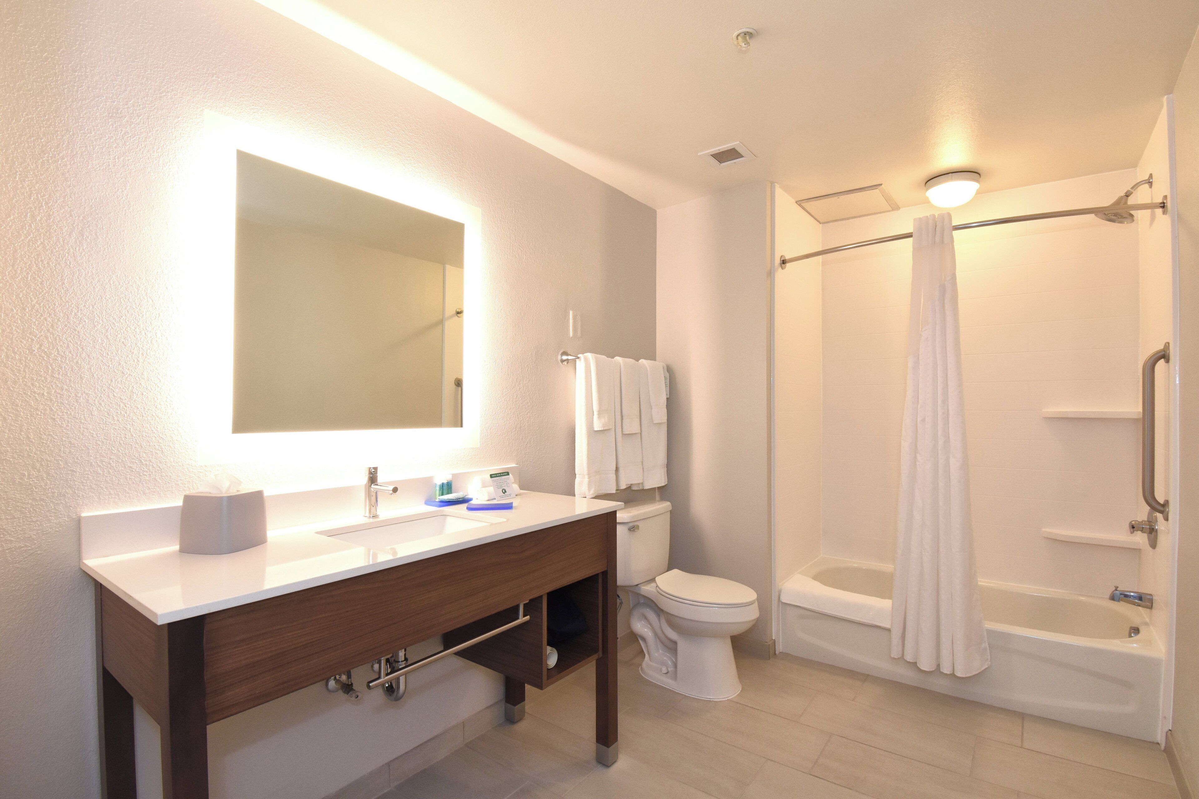 A modern bathroom with a vanity, toilet, and a walk-in shower.