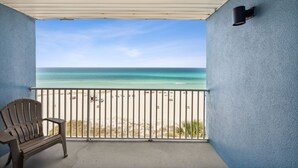 A balcony with a view of the beach and ocean.