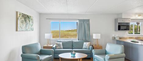 A modern living room with a sofa set, a coffee table, and a view of the outdoors.