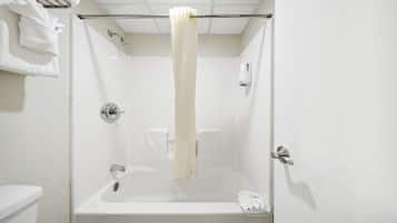 A white bathroom with a bathtub, a toilet, and a towel rack.