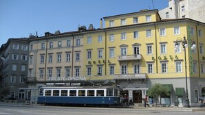 A yellow building with a sign reading "HOTEL" and "POSTA" on the side. - Albergo Alla Posta (Trieste)